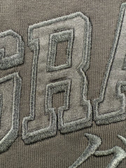 Close-up of embroidered grappler satin text and katakana on a black jersey knit tee shirt