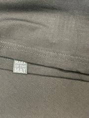 Close-up of a black tee shirt fabric with hidden detail 'Mark of the Mat' woven label on hem
